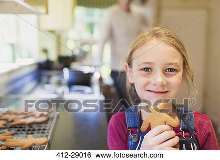 Portrait smiling girl eating gingerbread cookie View Large Photo Image Stock Photograph - Portrait smiling girl eating gingerbread cookie. Fotosearch
