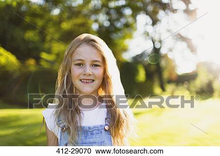 Stock Image - Portrait smiling girl in sunny garden. Fotosearch