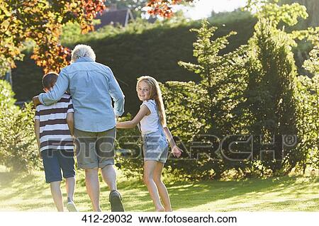 Portrait smiling girl walking with grandmother and brother in garden View Large Photo Image Stock Image - Portrait smiling girl walking with grandmother and brother in garden. Fotosearch