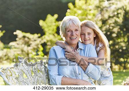 Portrait smiling grandmother and granddaughter hugging in garden View Large Photo Image Stock Photography - Portrait smiling grandmother and granddaughter hugging in garden. Fotosearch