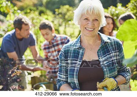Portrait smiling senior woman in sunny garden with family View Large Photo Image Stock Photograph - Portrait smiling senior woman in sunny garden with family. Fotosearch