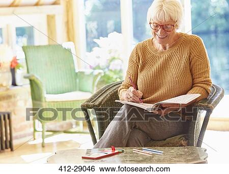 Senior woman coloring in coloring book View Large Photo Image Stock Photograph - Senior woman coloring in coloring book. Fotosearch