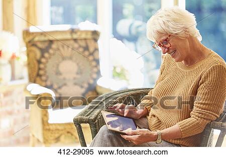 Stock Photography - Senior woman using digital tablet. Fotosearch