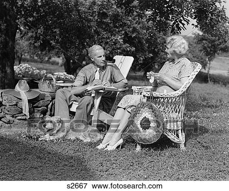 1940S Senior Retired Couple Sitting Outdoor Lawn Chairs Man Smoking Pipe Woman Knitting View Large Photo Image Stock Photo - 1940S Senior Retired Couple Sitting Outdoor Lawn Chairs Man Smoking Pipe Woman Knitting . Fotosearch