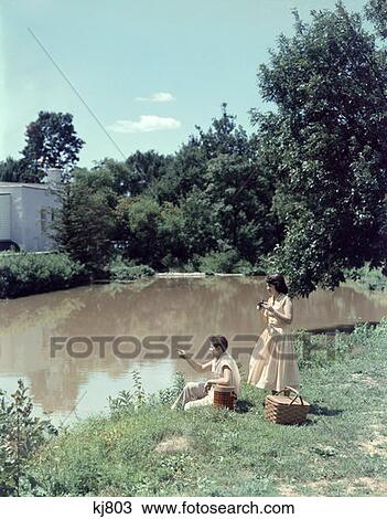 1950 1950S Teen Couple Boy Girl Picnic Basket On Bank Of Stream Summer Day Date Camera Retro View Large Photo Image Stock Image - 1950 1950S Teen Couple Boy Girl Picnic Basket On Bank Of Stream Summer Day Date Camera Retro . Fotosearch