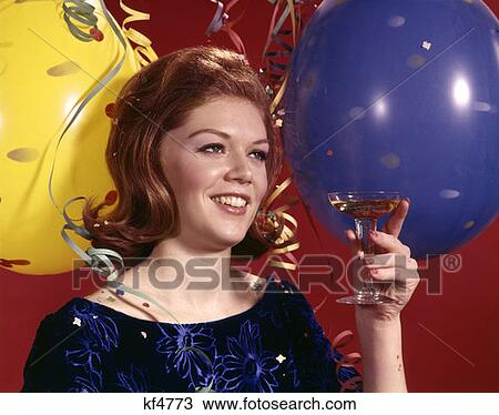 1960 1960S Young Woman Smiling Toasting Toast Glass Champagne Balloons Streamers Background Party New Years Retro View Large Photo Image Stock Image - 1960 1960S Young Woman Smiling Toasting Toast Glass Champagne Balloons Streamers Background Party New Years Retro . Fotosearch