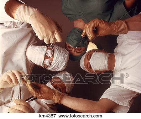 1970 1970S 4 Person Surgical Team From Below Patient Point Of View Doctor Nurse Surgeon Doctors Surgery Operation View Large Photo Image Stock Photo - 1970 1970S 4 Person Surgical Team From Below Patient Point Of View Doctor Nurse Surgeon Doctors Surgery Operation . Fotosearch