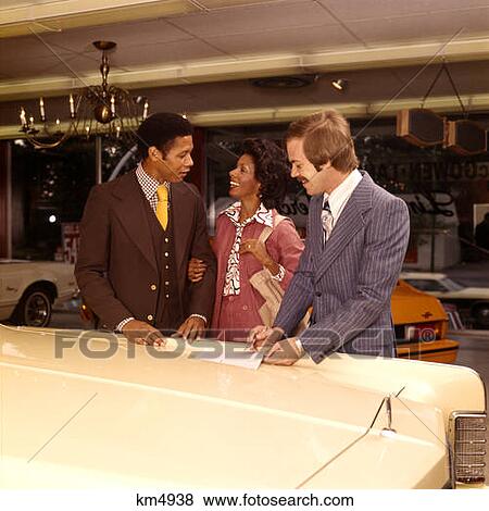 1970 1970S African-American Couple Man Woman Buying New Car With Salesman Dealer Automobile Showroom View Large Photo Image Stock Photo - 1970 1970S African-American Couple Man Woman Buying New Car With Salesman Dealer Automobile Showroom . Fotosearch
