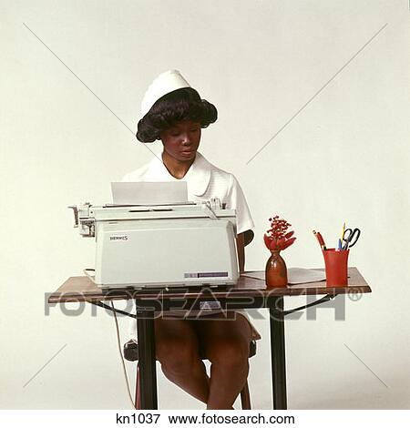 1970 1970S African-American Woman Nurse Seated Desk Typewriter Typing Doctors Office Paperwork Nurses Medical Health View Large Photo Image Stock Photo - 1970 1970S African-American Woman Nurse Seated Desk Typewriter Typing Doctors Office Paperwork Nurses Medical Health . Fotosearch