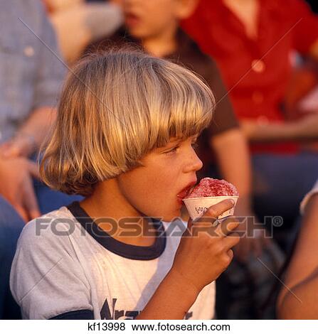 1970 1970S Blonde Blond Boy Beatles Type Haircut Hair Eating Sno-Cone Sno Cone Water Ice Snow Cone View Large Photo Image Stock Photo - 1970 1970S Blonde Blond Boy Beatles Type Haircut Hair Eating Sno-Cone Sno Cone Water Ice Snow Cone . Fotosearch