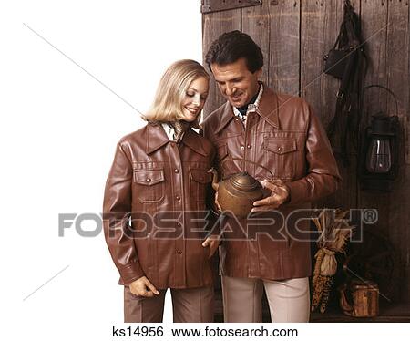 1970 1970S Couple Wearing Matched Matching Leather Jackets Holding Antique Copper Tea Kettle Retro View Large Photo Image Stock Photograph - 1970 1970S Couple Wearing Matched Matching Leather Jackets Holding Antique Copper Tea Kettle Retro. Fotosearch