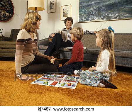1970 1970S Family Mother Father Boy Girl Playing Game Living Room Carpet Retro Parchessi Families Activity Board Games View Large Photo Image Stock Photo - 1970 1970S Family Mother Father Boy Girl Playing Game Living Room Carpet Retro Parchessi Families Activity Board Games . Fotosearch