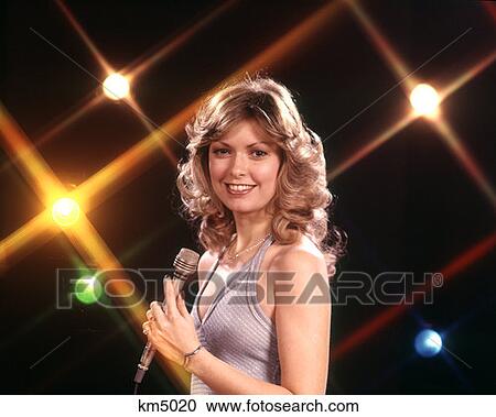 1970 1970S Female Vocalist Singer Hold Microphone Stage Lights Background Sing Singer Singing Performer Woman Women View Large Photo Image Stock Image - 1970 1970S Female Vocalist Singer Hold Microphone Stage Lights Background Sing Singer Singing Performer Woman Women . Fotosearch