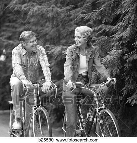 1970 1970S Happy Smiling Active Mature Middleaged Couple Riding Bicycles Bikes Pine Wooded Trail Activity Sports Retire Exercise View Large Photo Image Stock Image - 1970 1970S Happy Smiling Active Mature Middleaged Couple Riding Bicycles Bikes Pine Wooded Trail Activity Sports Retire Exercise. Fotosearch