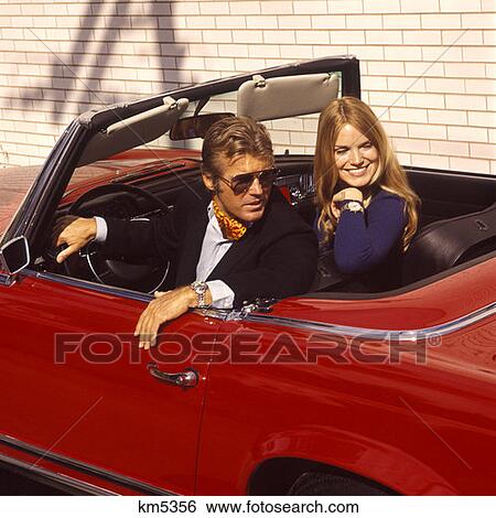 1970 1970S Man Woman Couple Fashionable Sitting Red Sports Card Convertible Fashion Style Cars Automobile Auto Autos View Large Photo Image Stock Photograph - 1970 1970S Man Woman Couple Fashionable Sitting Red Sports Card Convertible Fashion Style Cars Automobile Auto Autos . Fotosearch