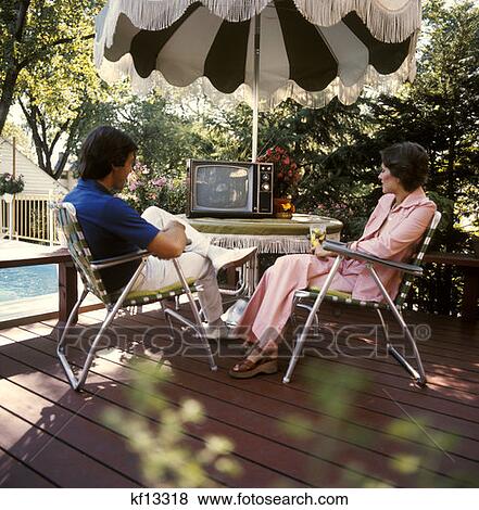 1970 1970s Man Woman Couple Patio Sitting Tabel Umbrella Shade