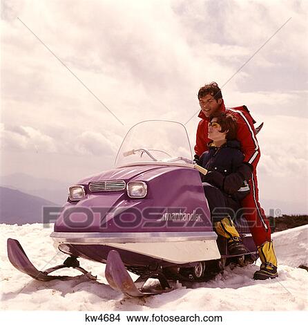 Picture - 1970 1970S Man Woman Couple Snowmobile Winter Sport Snow Men Women Couples Snowmobiles Snow Vehicle Retro . Fotosearch