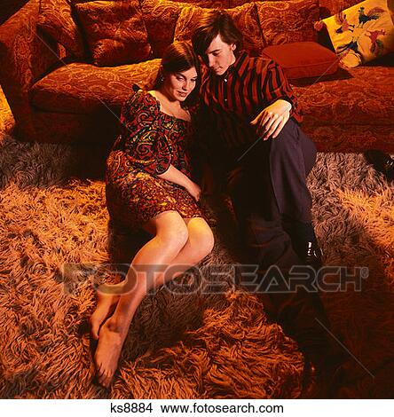 1970 1970S Man Woman Couple Young Adults Teen Teens Sitting On Shag Rug By Couch Fireplace Romance Romantic Fashion Retro View Large Photo Image Picture - 1970 1970S Man Woman Couple Young Adults Teen Teens Sitting On Shag Rug By Couch Fireplace Romance Romantic Fashion Retro . Fotosearch