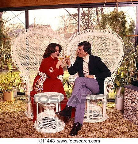 1970 1970S Man Woman Drinking Wine Patio Sitting White Wicker Rattan Tropical Motif Chairs Furniture Couples Couple View Large Photo Image Stock Image - 1970 1970S Man Woman Drinking Wine Patio Sitting White Wicker Rattan Tropical Motif Chairs Furniture Couples Couple . Fotosearch