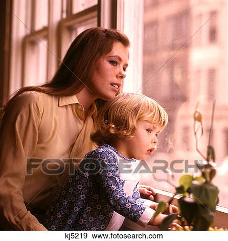 Stock Photo - 1970 1970S Mother Child Looking Out Window Watching Mothers Toddler Toddlers Windows Family Families Retro . Fotosearch