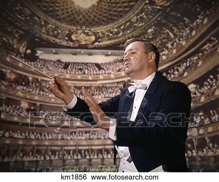1970 1970S Retro Conductor Maestro Symphony Orchestra Tuxedo With Audience Theatre Background View Large Photo Image Stock Photograph - 1970 1970S Retro Conductor Maestro Symphony Orchestra Tuxedo With Audience Theatre Background. Fotosearch