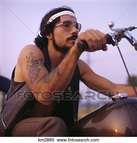 1970 1970S Retro Man Motorcycle Easy Rider With Headband Tattoos Mustache Beard Wire Frame Glasses View Large Photo Image Stock Photography - 1970 1970S Retro Man Motorcycle Easy Rider With Headband Tattoos Mustache Beard Wire Frame Glasses . Fotosearch