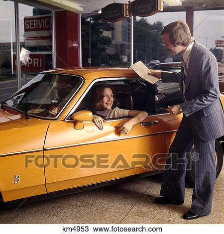 1970 1970S Woman Sitting Drivers Seat Orange Car Buy New Automobile Salesman Dealer Dealership Showroom Test Drive View Large Photo Image Stock Image - 1970 1970S Woman Sitting Drivers Seat Orange Car Buy New Automobile Salesman Dealer Dealership Showroom Test Drive . Fotosearch
