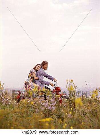 1970 1970S Young Couple Man Woman Romantic Riding Red Motorcycle Motor Bike Field Flowers View Large Photo Image Stock Photo - 1970 1970S Young Couple Man Woman Romantic Riding Red Motorcycle Motor Bike Field Flowers . Fotosearch