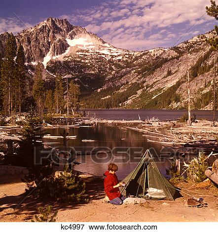 1970 197Os Teen Boy Kneeling Campsite Green Tent Tents Washing Tin Cup Snow Lakes Mcclellan Peak Washington State View Large Photo Image Stock Photo - 1970 197Os Teen Boy Kneeling Campsite Green Tent Tents Washing Tin Cup Snow Lakes Mcclellan Peak Washington State . Fotosearch