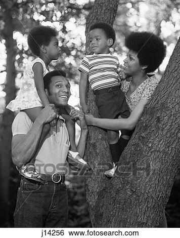 1970S African-American Family Outdoors By Trunk Of Tree Mother Father Boy Girl View Large Photo Image Stock Photograph - 1970S African-American Family Outdoors By Trunk Of Tree Mother Father Boy Girl . Fotosearch