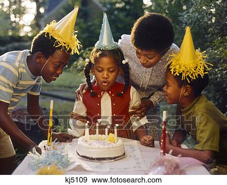 1970S African American Mother 3 Children Little Girl Blowing Out Candles Birthday Cake 2 Boys In Yellow Paper Party Hats View Large Photo Image Stock Photo - 1970S African American Mother 3 Children Little Girl Blowing Out Candles Birthday Cake 2 Boys In Yellow Paper Party Hats. Fotosearch