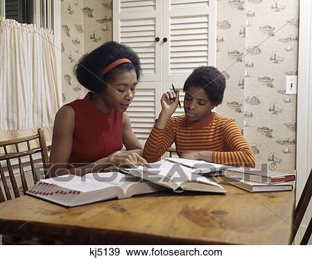 1970S African-American Mother And Girl Daugheter Doing Homework Together Kitchen Table Dictionary Study View Large Photo Image Stock Photo - 1970S African-American Mother And Girl Daugheter Doing Homework Together Kitchen Table Dictionary Study . Fotosearch