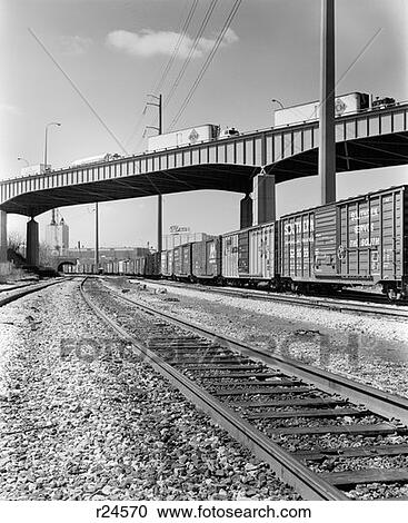 1970S Angled View Of Freight Train Passing Under Highway Bridge View Large Photo Image Stock Image - 1970S Angled View Of Freight Train Passing Under Highway Bridge . Fotosearch