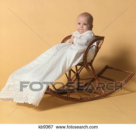 1970S Baby Girl In Christening Outfit Sitting On Wooden Rocker View Large Photo Image Stock Photo - 1970S Baby Girl In Christening Outfit Sitting On Wooden Rocker. Fotosearch