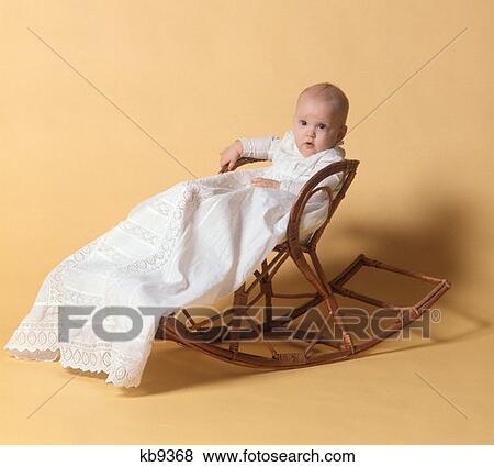 1970S Baby In Christening Outfit Sitting On Wooden Rocker View Large Photo Image Stock Photo - 1970S Baby In Christening Outfit Sitting On Wooden Rocker. Fotosearch