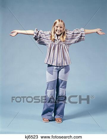 1970S Blond Teen Girl Standing Full Length Wearing Patchwork Bell Bottom Denim Blue Jeans Arms Stretched Out View Large Photo Image Stock Image - 1970S Blond Teen Girl Standing Full Length Wearing Patchwork Bell Bottom Denim Blue Jeans Arms Stretched Out . Fotosearch
