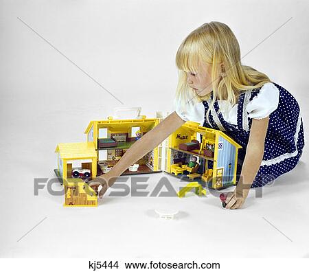 1970S Blonde Girl Polka Dot Dress Play With Hinged Folding Doll House Toy Gender Role Playing View Large Photo Image Picture - 1970S Blonde Girl Polka Dot Dress Play With Hinged Folding Doll House Toy Gender Role Playing. Fotosearch