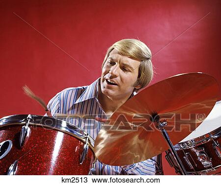 1970S Blonde Man Striped Shirt Red Background Playing Drums Drum Drumming Cymbal Percussion Music Musician Rhythm View Large Photo Image Stock Image - 1970S Blonde Man Striped Shirt Red Background Playing Drums Drum Drumming Cymbal Percussion Music Musician Rhythm. Fotosearch