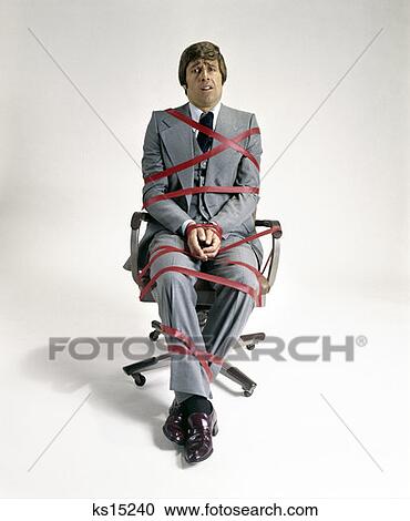 1970S Business Man Tied Up In Red Tape Sitting In Office Desk Chair Symbolic View Large Photo Image Stock Image - 1970S Business Man Tied Up In Red Tape Sitting In Office Desk Chair Symbolic . Fotosearch