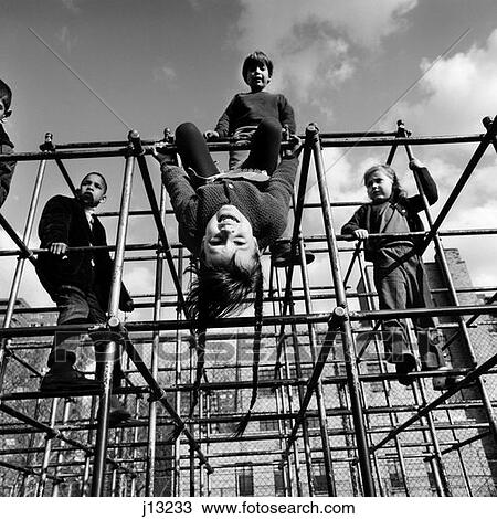 1970S Children Boys Girls Climbing On Bars Of Jungle Gym Playground One Kid Hanging Upside Down View Large Photo Image Stock Image - 1970S Children Boys Girls Climbing On Bars Of Jungle Gym Playground One Kid Hanging Upside Down . Fotosearch