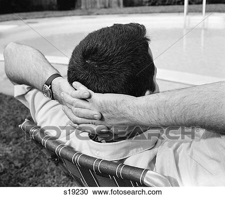 1970S Close-Up Back View Of Man With Hands Folded Behind Head Stretched Out In Lounge Chair Poolside View Large Photo Image Stock Image - 1970S Close-Up Back View Of Man With Hands Folded Behind Head Stretched Out In Lounge Chair Poolside . Fotosearch