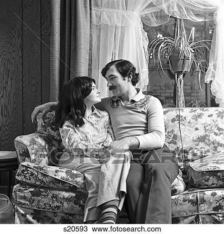 1970S Couple Husband Wife Sitting Together On Couch Hugging Holding Hands Romantic View Large Photo Image Stock Image - 1970S Couple Husband Wife Sitting Together On Couch Hugging Holding Hands Romantic . Fotosearch