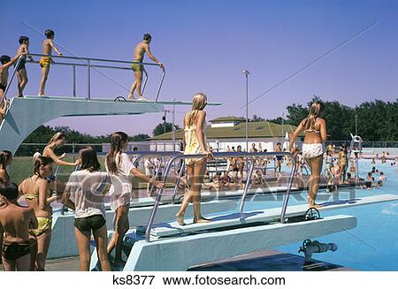 1970S Crowd Of Teens In Pool & On Diving Board At Municipal Swim Pool Mcpherson Kansas Summer Fun Recreation Cool Wet View Large Photo Image Stock Photo - 1970S Crowd Of Teens In Pool & On Diving Board At Municipal Swim Pool Mcpherson Kansas Summer Fun Recreation Cool Wet. Fotosearch