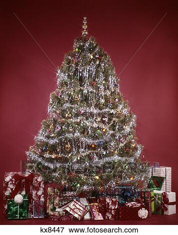 1970S Evergreen Tree On Red Background Decorations Tinsel Garland Ornaments Gifts Presents Retro Vintage View Large Photo Image Stock Photo - 1970S Evergreen Tree On Red Background Decorations Tinsel Garland Ornaments Gifts Presents Retro Vintage. Fotosearch