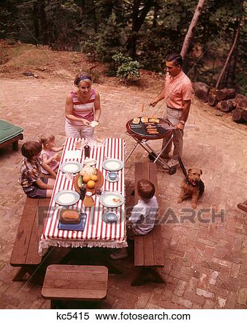 1970S Family Man Father Woman Mother Son Daughter Dog Backyard Picnic Barbecue Hot Dog Hamburger Grill Table Trees View Large Photo Image Stock Photography - 1970S Family Man Father Woman Mother Son Daughter Dog Backyard Picnic Barbecue Hot Dog Hamburger Grill Table Trees . Fotosearch
