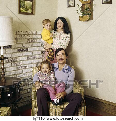 1970S Family Portrait Living Room Man Father Sitting Chair Woman Mother Standing Two Kids Fashion Clothes View Large Photo Image Stock Image - 1970S Family Portrait Living Room Man Father Sitting Chair Woman Mother Standing Two Kids Fashion Clothes. Fotosearch