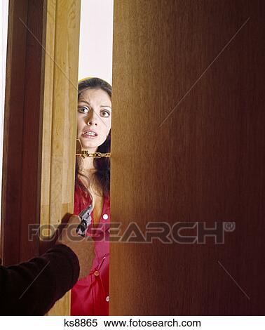 1970S Fear Frightened Woman Opening Door Ajar Held By Security Chain Hand Of Man Criminal Holding Gun View Large Photo Image Stock Photography - 1970S Fear Frightened Woman Opening Door Ajar Held By Security Chain Hand Of Man Criminal Holding Gun. Fotosearch