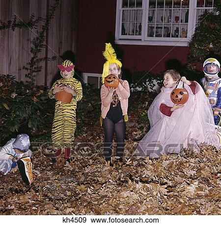 1970S Group 5 Children Costumes Boys & Girls Hold Trick Or Treat Pumpkins Bags Window House Autumn Leaves View Large Photo Image Stock Photo - 1970S Group 5 Children Costumes Boys & Girls Hold Trick Or Treat Pumpkins Bags Window House Autumn Leaves. Fotosearch