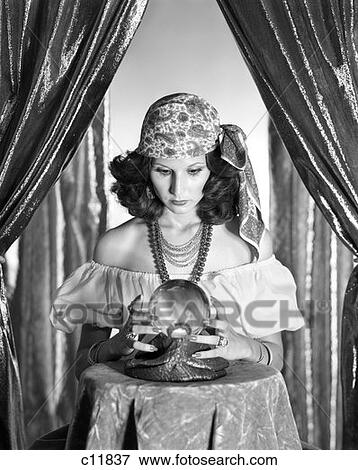 1970S Gypsy Between Sparkly Curtains Peering Into Crystal Ball With Hands Around It  View Large Photo Image Stock Photo - 1970S Gypsy Between Sparkly Curtains Peering Into Crystal Ball With Hands Around It . Fotosearch
