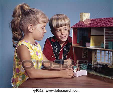 Stock Image - 1970S Little Boy And Girl Playing With Dollhouse Two. Fotosearch